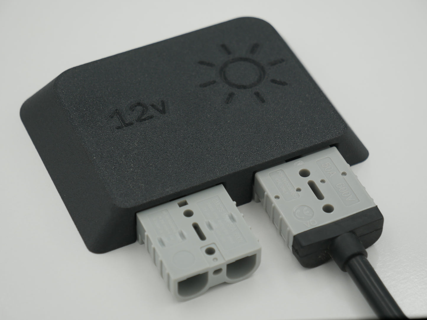 Black Anderson Plug Mount with '12V' marking on a white background