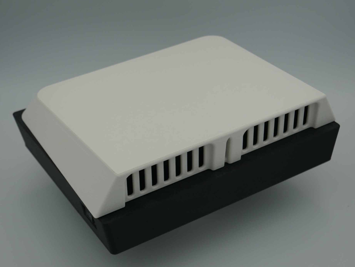 A rectangular 12volt canopy Air Vent, the outter housing in White and the body in black, canopy ventilation.