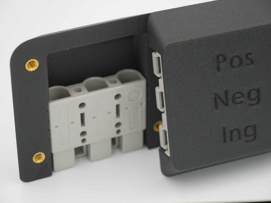 Close-up of a black Triple Anderson Mount with Pos, Neg, Ing labels for 12V system connections